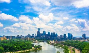 Surveyor conducting a topographic land survey on an open lot using tripod equipment in Pittsburgh, Pennsylvania.
