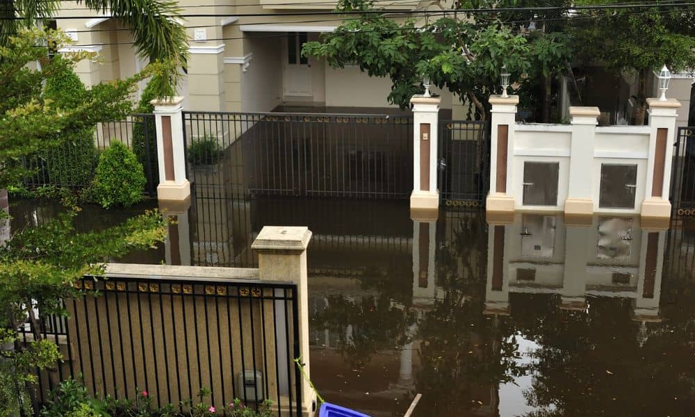 Flooded residential driveway showing high water after heavy rain, highlighting the need to update an elevation certificate
