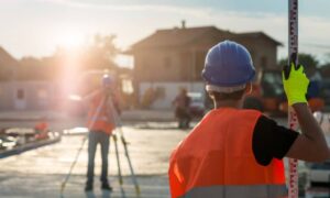 Land surveyors verifying property measurements during an ALTA land title survey before closing