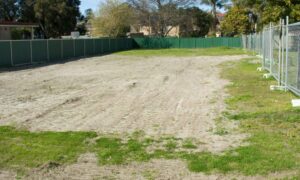 Vacant residential lot with fencing on multiple sides where a boundary survey helps clarify property lines during redevelopment