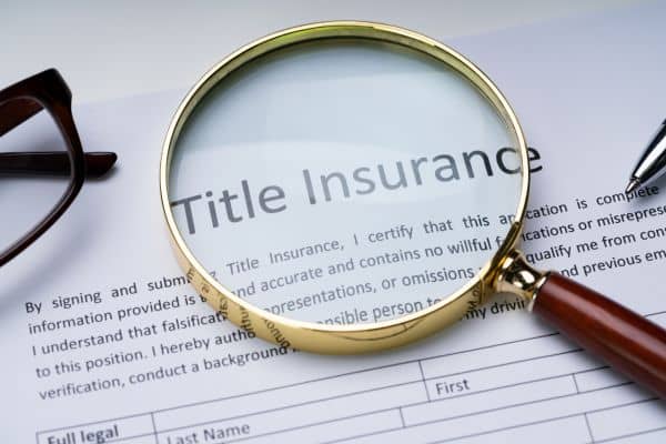 Magnifying glass highlighting title insurance—used to illustrate the role of an ALTA survey in protecting property buyers in Philadelphia.