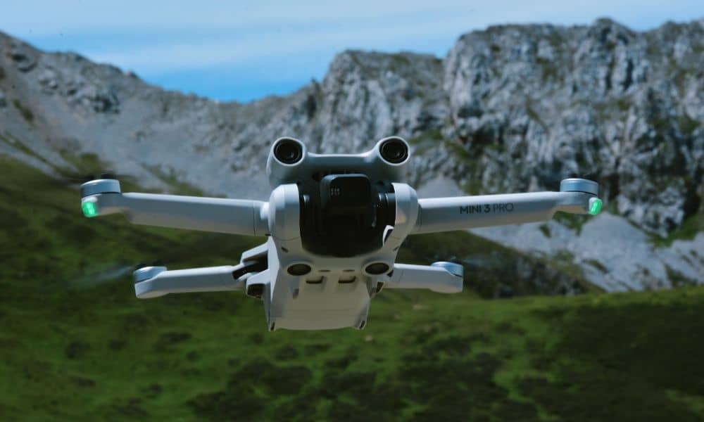 Drone flying over rugged mountainous terrain capturing aerial data for land surveying
