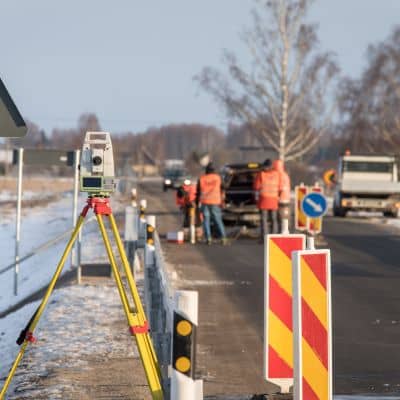 Survey equipment measuring elevation changes along a roadway where a topo survey supports infrastructure safety
