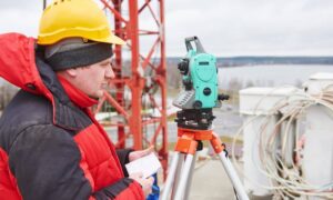 Surveyor setting up equipment for construction surveys at an urban site