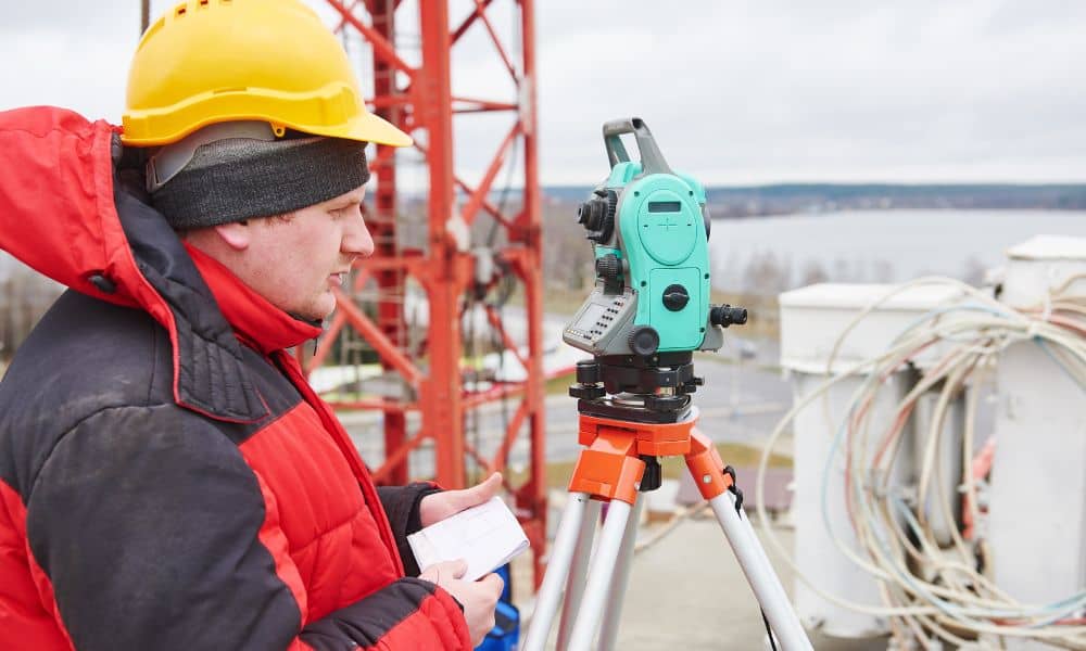 Surveyor setting up equipment for construction surveys at an urban site