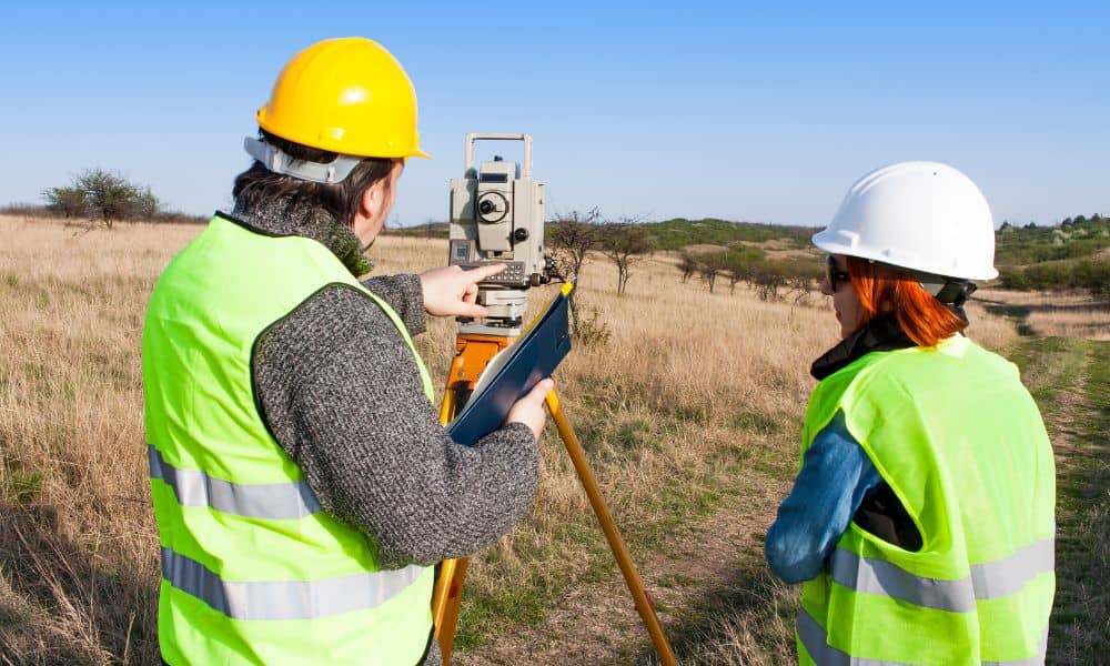 Land surveyor checking site elevation for FEMA elevation certificates during a property review