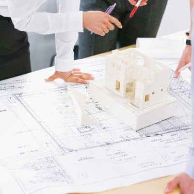 Professionals reviewing survey plans and measurements where a boundary survey provides documented evidence to resolve property line disputes