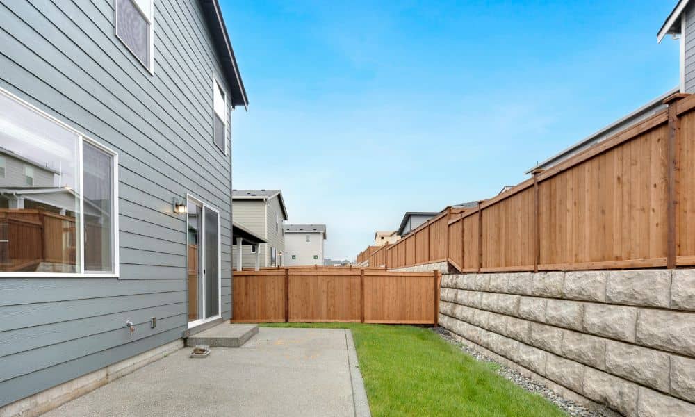 Backyard fence between two neighboring houses showing a property boundary that may require an ALTA land survey to confirm