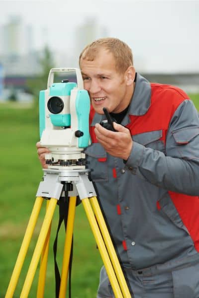 Land surveyor using total station - ALTA SURVEY Pennsylvania Licensed land surveyor using surveying equipment during an ALTA land survey to measure property boundaries
