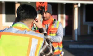 Surveyor checking property measurements with a total station during a site survey