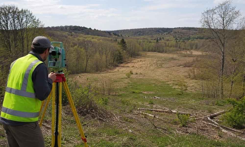 Average cost for a land survey near Pittsburgh - ALTA SURVEY Pennsylvania A land surveyor works on vacant rural property near Pittsburgh, showing the terrain that can affect the average cost for a land survey