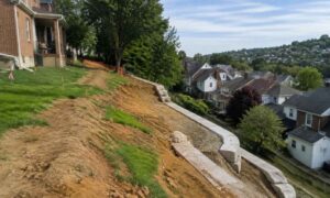 Sloped residential yard in Pittsburgh Pennsylvania showing topographic survey conditions for retaining wall planning